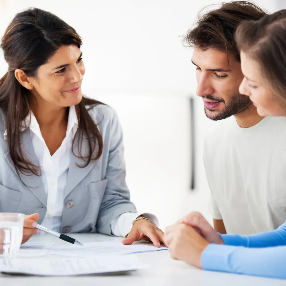 Man and woman sitting at a table, looking at paperwork and a pen