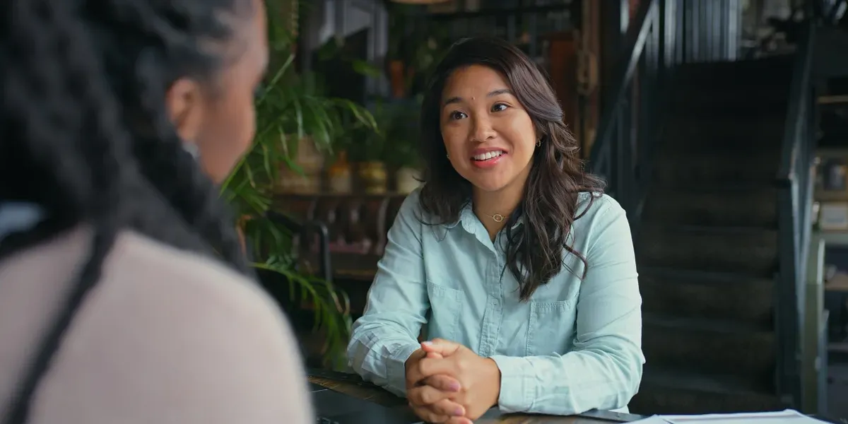 Two women sitting at a table, and engaged in conversation