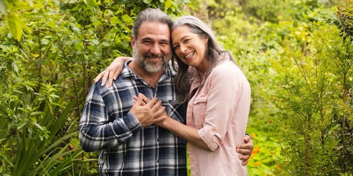 Man and woman standing in a garden, at each other