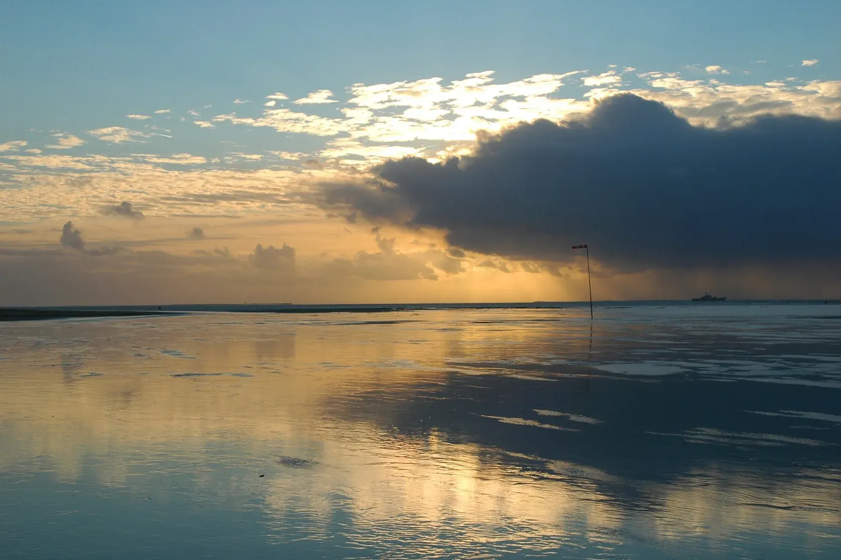 Sunset over the ocean with a boat in the distance